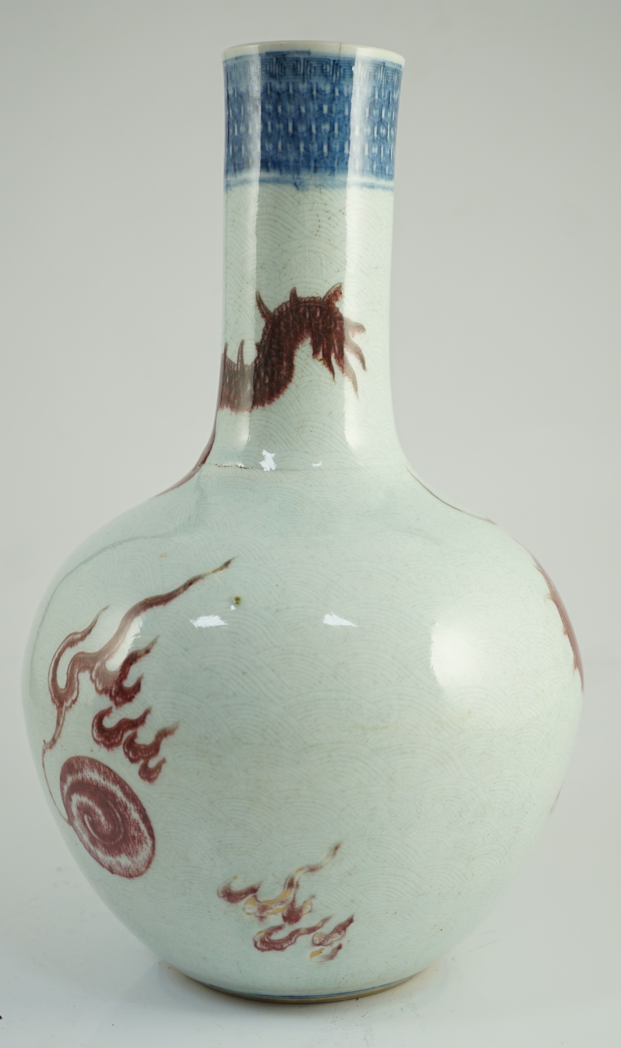 A rare Chinese underglaze blue and copper red 'dragon' vase, tianqiuping, 18th century, 38cm high, firing faults, hairline cracks